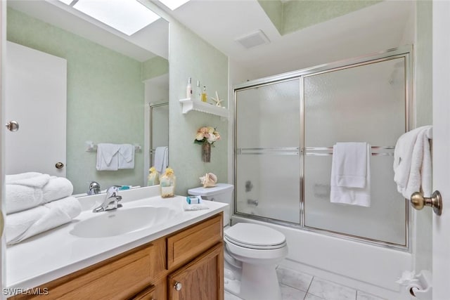 full bathroom with toilet, vanity, shower / bath combination with glass door, and a skylight