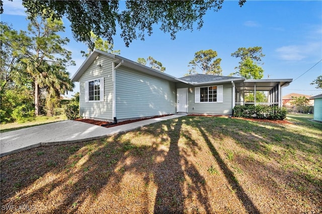 ranch-style home featuring a front yard and a sunroom