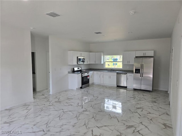 kitchen with appliances with stainless steel finishes, sink, and white cabinets