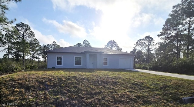 ranch-style house featuring a garage and a front lawn