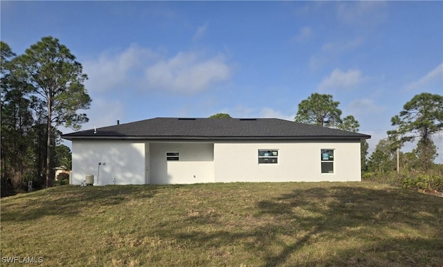 rear view of property featuring a lawn