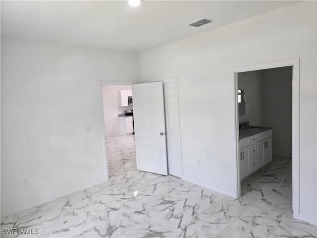 unfurnished bedroom featuring ensuite bath and a closet