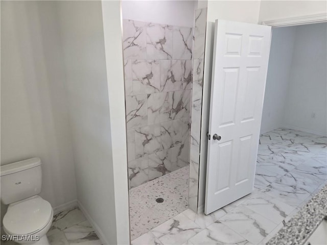 bathroom featuring toilet and a tile shower