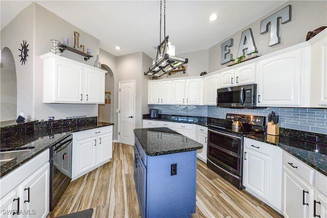 kitchen with white cabinets, dark stone counters, a kitchen island, and black appliances