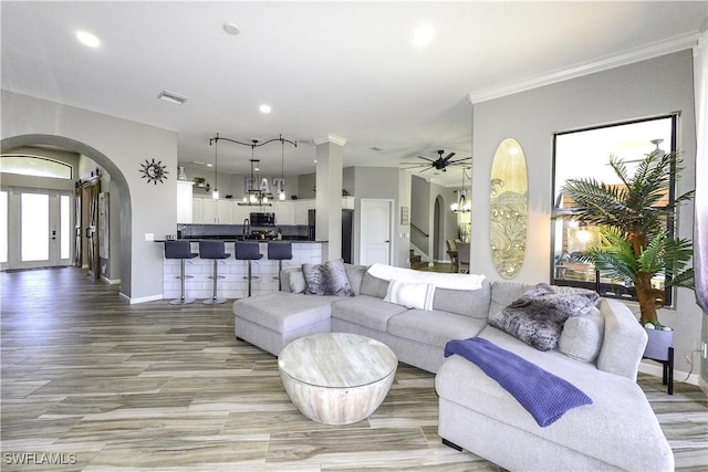 living room with crown molding, ceiling fan, and light hardwood / wood-style flooring