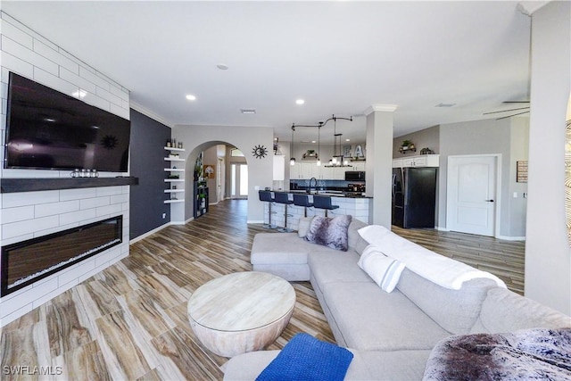 living room with sink, hardwood / wood-style flooring, and a large fireplace