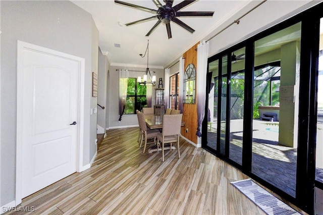 dining space featuring ceiling fan with notable chandelier, ornamental molding, and light hardwood / wood-style floors