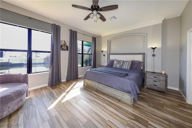 bedroom with hardwood / wood-style floors, ornamental molding, and ceiling fan