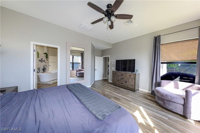 bedroom featuring connected bathroom, light hardwood / wood-style flooring, and ceiling fan