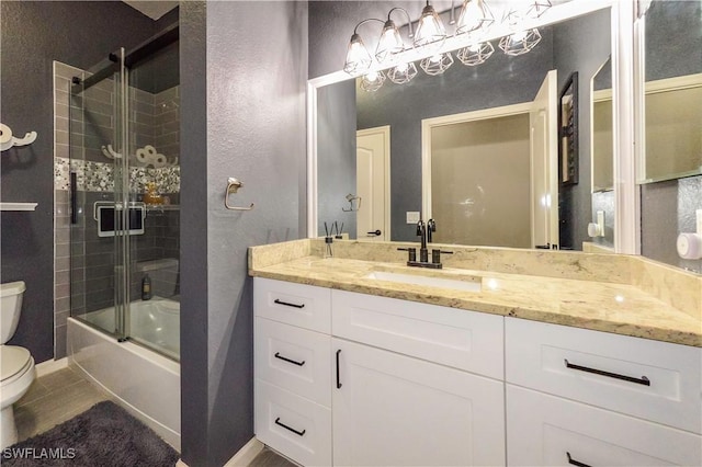 full bathroom featuring vanity, shower / bath combination with glass door, and toilet