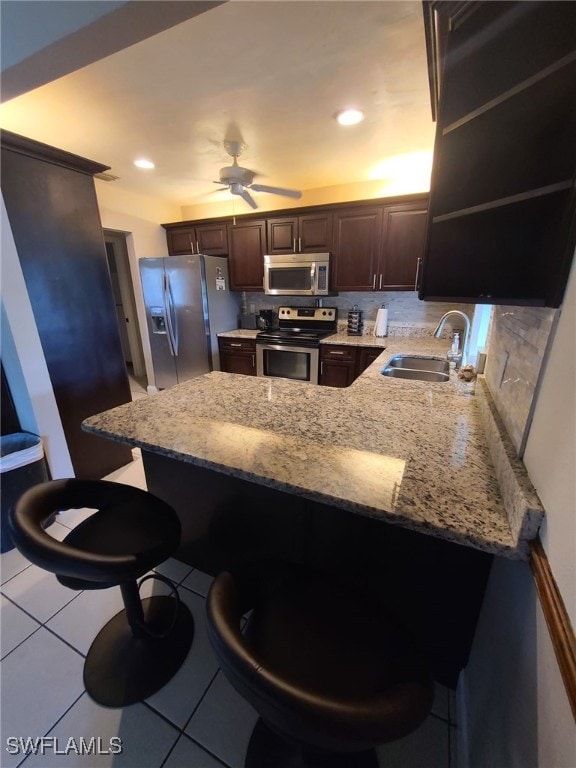 kitchen with stainless steel appliances, a peninsula, and a breakfast bar area