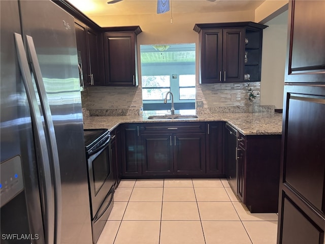 kitchen featuring light stone countertops, stainless steel appliances, open shelves, a sink, and light tile patterned flooring