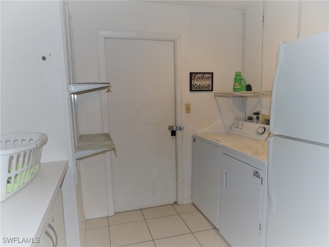 clothes washing area with washer and dryer, laundry area, and light tile patterned floors