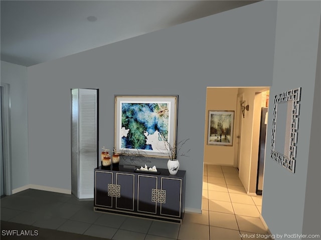 corridor with vaulted ceiling, baseboards, and tile patterned floors