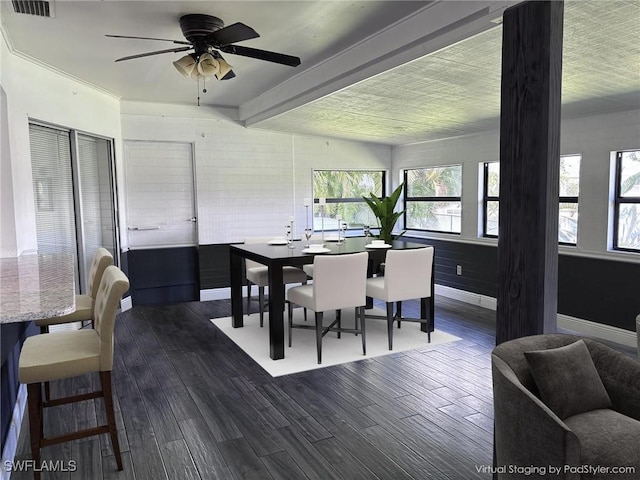 dining space featuring baseboards, a ceiling fan, dark wood-type flooring, and beamed ceiling