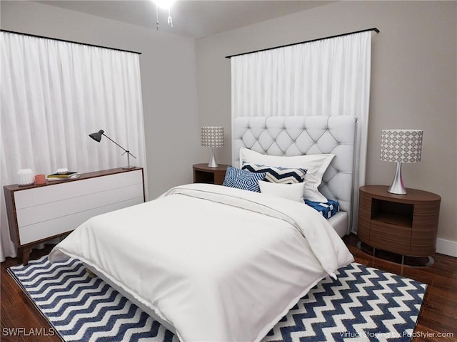 bedroom featuring dark wood finished floors and baseboards