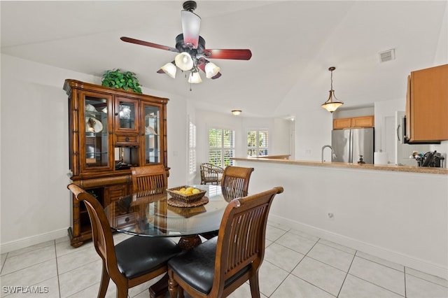 dining space featuring lofted ceiling, light tile patterned floors, sink, and ceiling fan