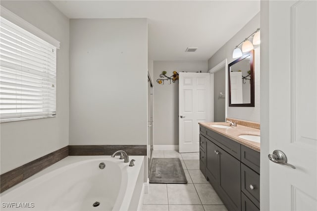 bathroom with vanity, tile patterned flooring, and a tub