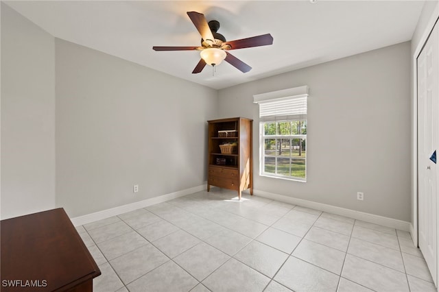 tiled empty room featuring ceiling fan