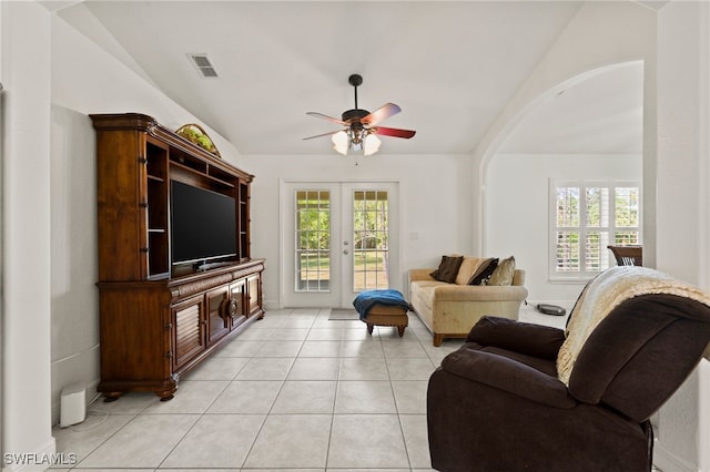 living room with french doors, lofted ceiling, plenty of natural light, and light tile patterned flooring