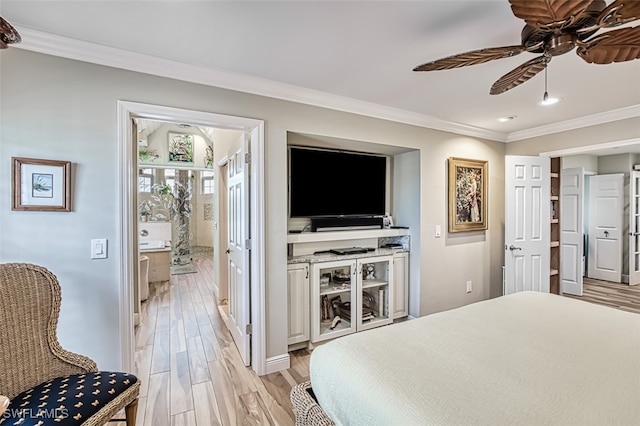 bedroom featuring ornamental molding, ceiling fan, light hardwood / wood-style floors, and ensuite bath