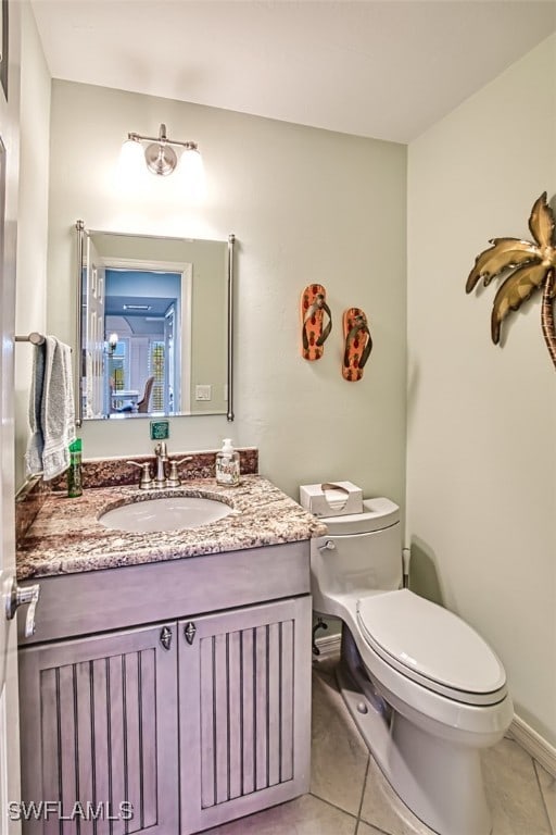 bathroom featuring vanity, tile patterned floors, and toilet