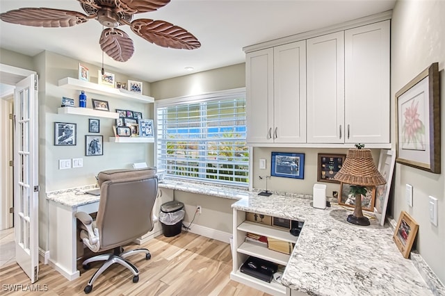 home office with ceiling fan, built in desk, and light hardwood / wood-style floors