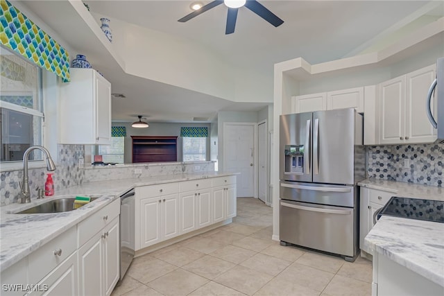 kitchen with sink, appliances with stainless steel finishes, tasteful backsplash, light stone countertops, and white cabinets