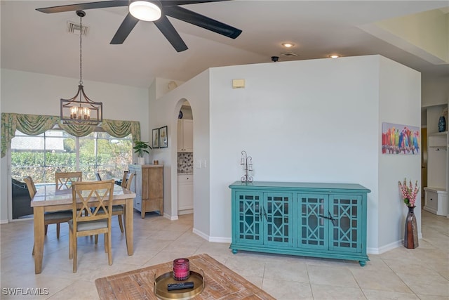 tiled dining space featuring ceiling fan with notable chandelier