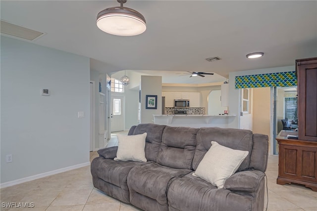 tiled living room with ceiling fan