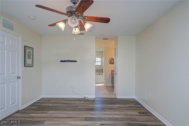 spare room featuring ceiling fan and dark hardwood / wood-style flooring