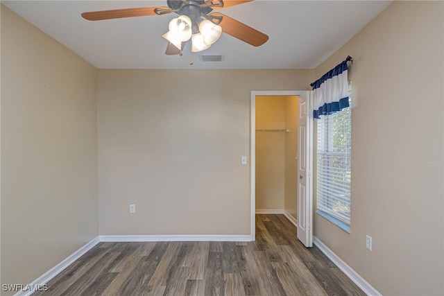 empty room featuring dark wood-type flooring and ceiling fan