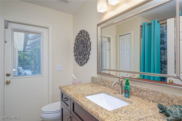 bathroom featuring vanity and toilet