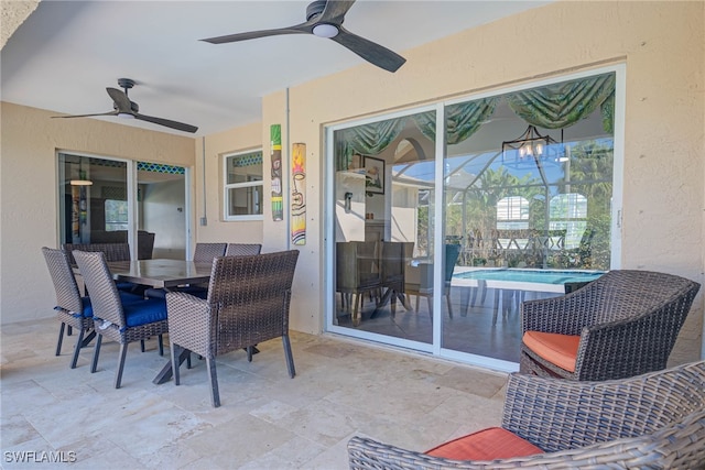 view of patio with ceiling fan and glass enclosure