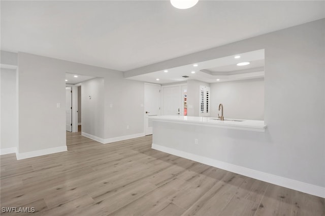 unfurnished living room with sink and light wood-type flooring