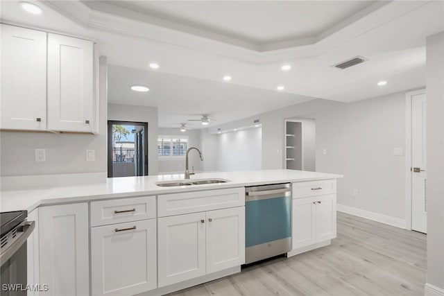 kitchen featuring stainless steel appliances, sink, light hardwood / wood-style flooring, and white cabinets