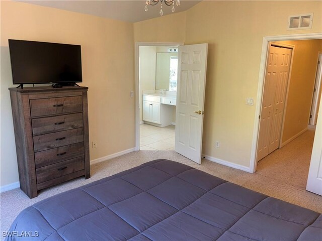 bedroom featuring light carpet, baseboards, vaulted ceiling, a chandelier, and a sink