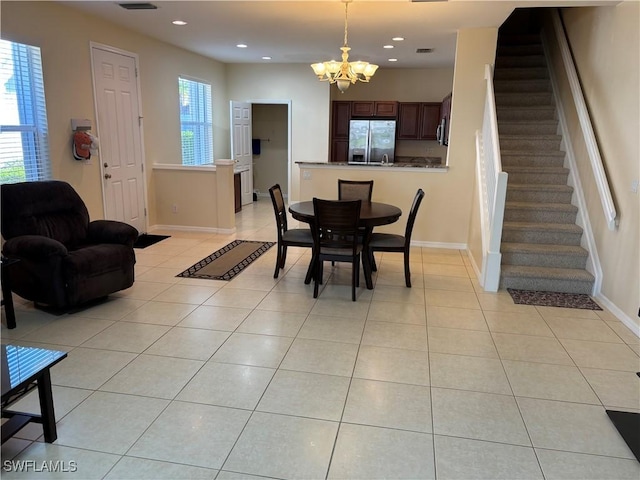 tiled dining room featuring a notable chandelier