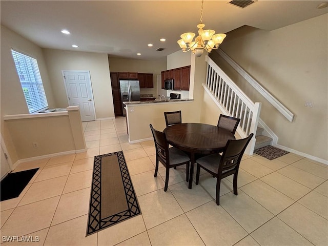 tiled dining area featuring a chandelier