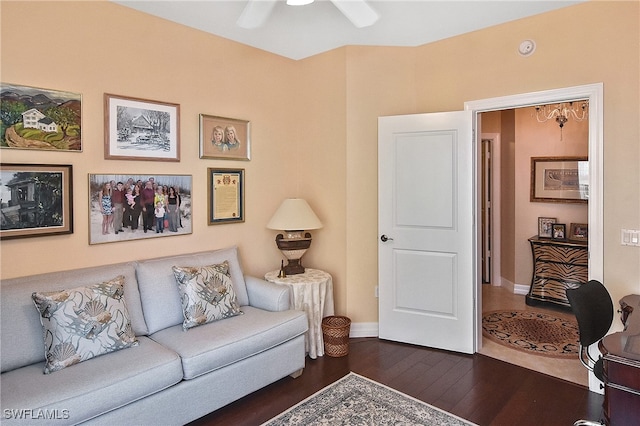 living room with dark wood-type flooring and ceiling fan