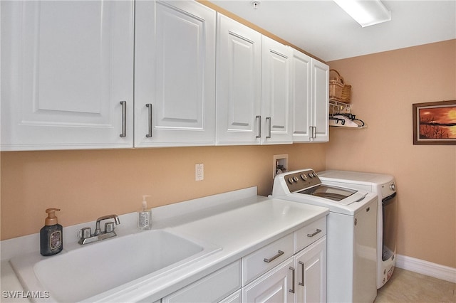 laundry room featuring cabinets, sink, washing machine and dryer, and light tile patterned floors