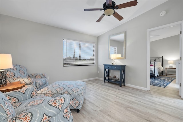 bedroom with ceiling fan, lofted ceiling, and light wood-type flooring