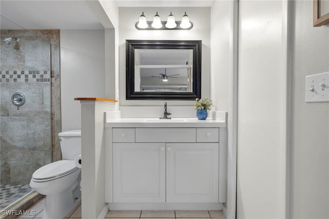 bathroom featuring tile patterned flooring, vanity, tiled shower, and toilet