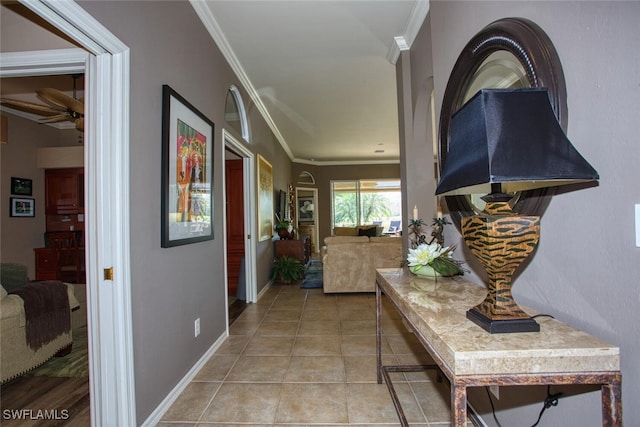 hallway with ornamental molding and light tile patterned floors