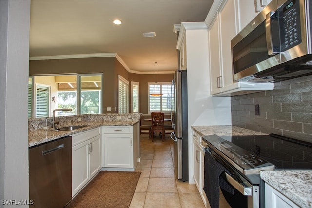 kitchen featuring pendant lighting, sink, appliances with stainless steel finishes, light stone counters, and white cabinets