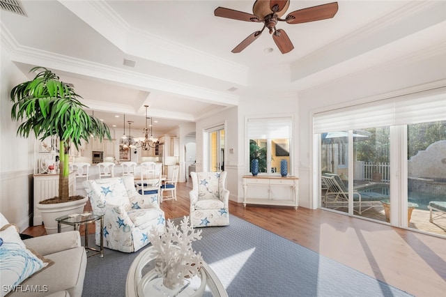 living room featuring crown molding, a tray ceiling, and hardwood / wood-style flooring