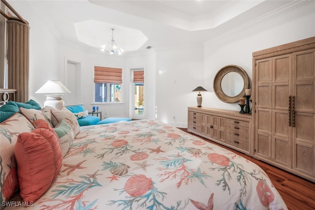 bedroom featuring a raised ceiling, ornamental molding, hardwood / wood-style floors, and a chandelier