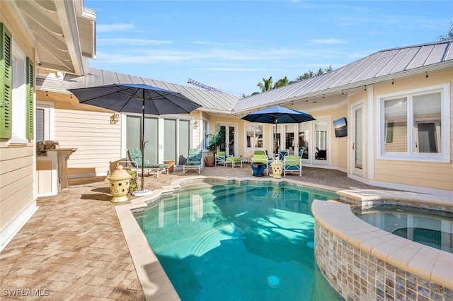 view of swimming pool featuring an in ground hot tub and a patio area