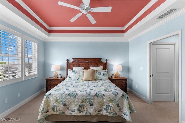 carpeted bedroom featuring ceiling fan, ornamental molding, and a raised ceiling