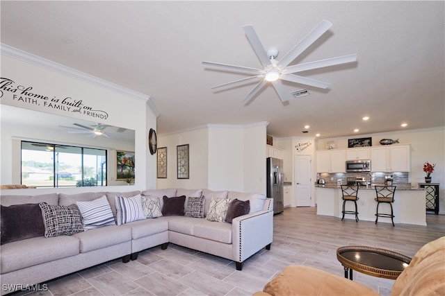 living room featuring ornamental molding and ceiling fan